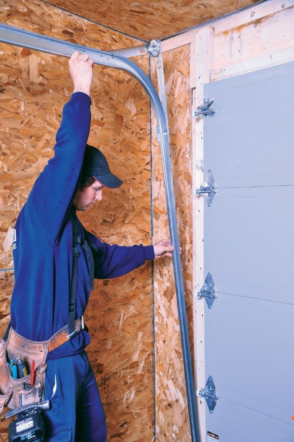 Installer installing garage door tracks