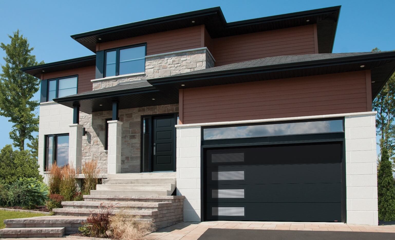 Maison en briques dans les teintes de beige, avec vinyle brun, un toit carré, agencés avec une porte de garage double de design Uni et Noir.