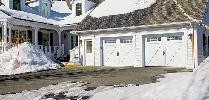 House in winter with Eastman E-21 garage doors, Ice White doors and overlays, 9' x 7', 8-pane Panoramic windows