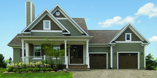 Charming country home, with a big garage, 2 garage doors in dark brown color, with windows and decorative hardware