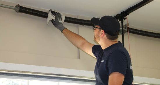 Garage door expert doing maintenance on garage door springs 