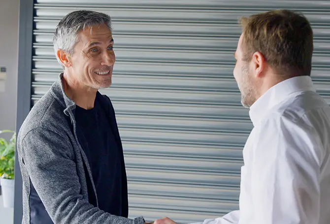 Un agent marketing de chez Garaga serrant la main d'un client pour conclure un accord pour des services marketing.