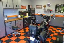 The interior of a well appointed garage with a black and orange tiled floor.