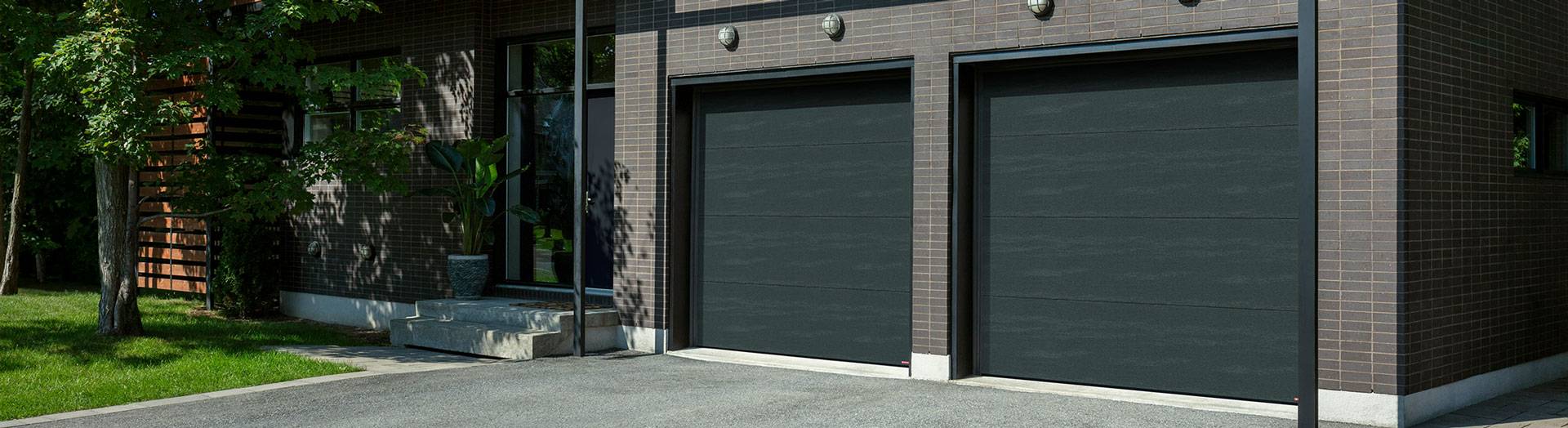 Modern exterior home design, blond wood, grey brick, 2 flush garage door in Iron Ore colors