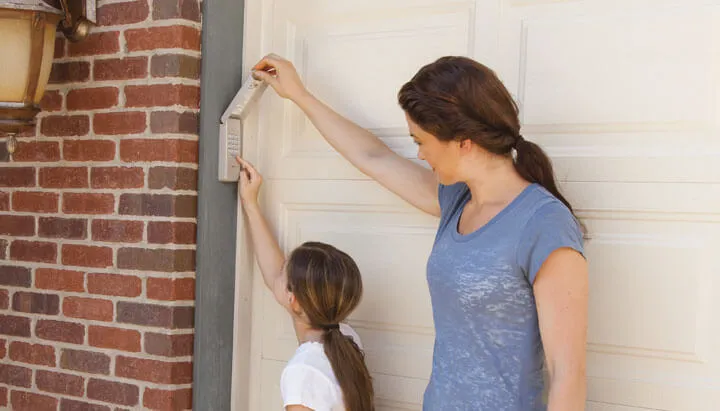 Une maman et sa fille passent du garage à la maison. La porte de garage a un verrou sécuritaire.