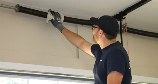 Expert en portes de garage qui fait l'entretien des rails d'une porte de garage